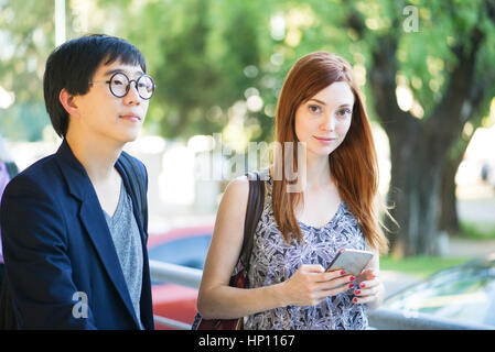 Donna che cammina sulla strada con un amico Foto Stock