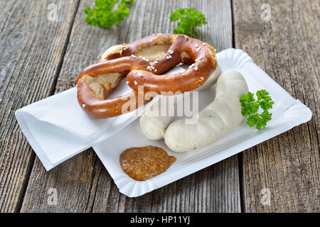 Bavarese di cibo di strada: Due Monaco di Baviera le salsicce bianche con una fresca pretzel e senape dolce su un piatto di carta Foto Stock