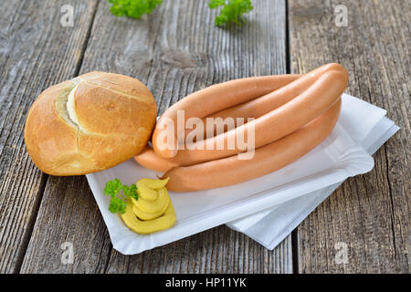 Il tedesco street food: Quattro wieners con un nuovo rotolo e senape piccante su un piatto di carta Foto Stock