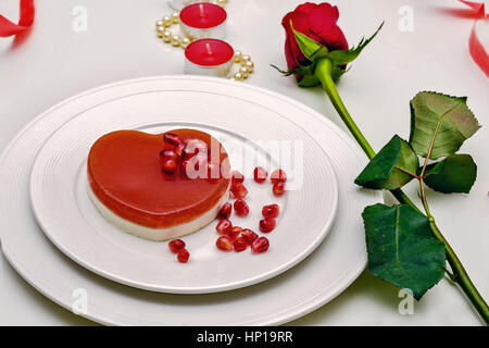 A forma di cuore torta rosso su una piastra bianca. Delizioso dessert per il giorno di San Valentino cena romantica Foto Stock