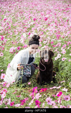 Giovane donna prende selfie con il cane Foto Stock