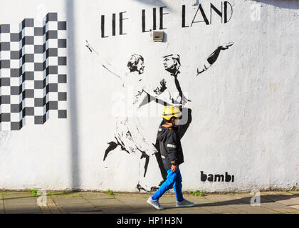 Islington, Londra, 17 feb 2017. I passanti da guardare a un nuovo graffiti da artista di strada Bambi che raffigura il presidente statunitense Donald Trump e British PM Theresa Maggio dancing in 'giacciono giacciono terreni", un riferimento per l'acclamato film "La La Terra". Il lavoro è apparso questa settimana su una strada laterale nel quartiere di Islington. Credito: Imageplotter News e sport/Alamy Live News Foto Stock