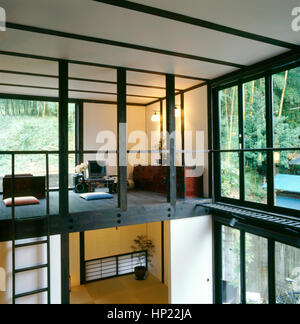 Interno di una contemporanea giapponese di casa: spazio aperto con un computer in un mezzanino di fronte ad un giardino Foto Stock