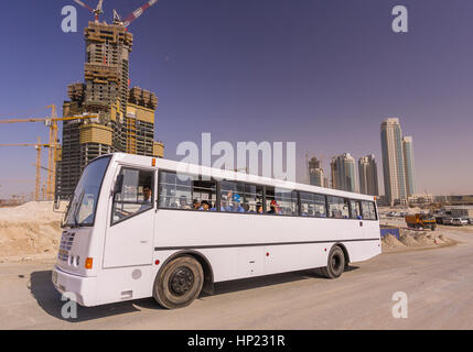 DUBAI, Emirati Arabi Uniti - autobus trasporta South Asian contratto operai dal sito della costruzione del Burj Khalifa, il grattacielo più alto del mondo, su Sheikh Zayed Road a Dubai. Foto Stock