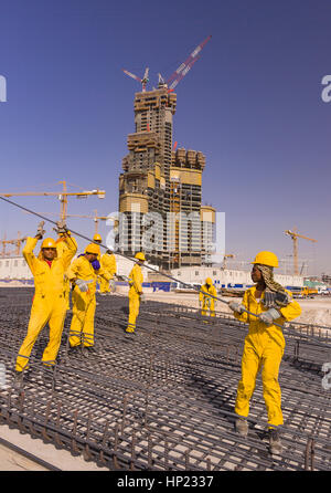 DUBAI, Emirati Arabi Uniti - South Asian contratto immigrati operai provenienti da Bangladesh, India e Pakistan lavorano presso il cantiere di Burj Khalifa o Burj Dubai, su Sheikh Zayed Road a Dubai. Il Burj Khalifa è mondo l'edificio più alto di 829 metri. Foto Stock