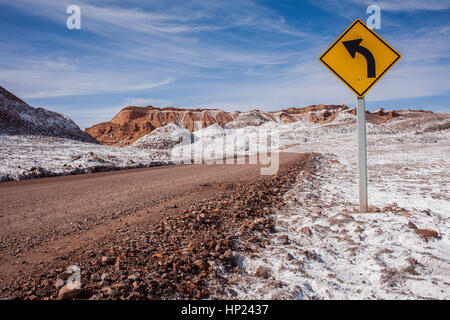 Pista, strada, attraverso la Valle de la Luna (Valle della Luna) e sale depositato sul terreno, deserto Atacama. Regione di Antofagasta. Cile Foto Stock