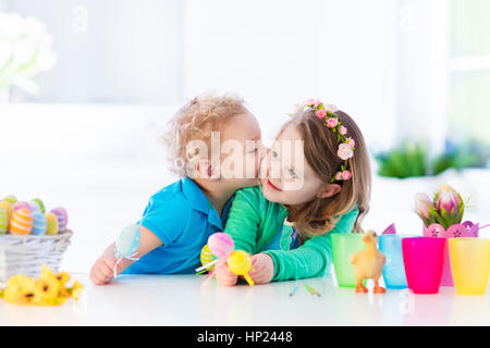 Pittura per bambini uova colorate. I bambini di vernice e decorare uovo di Pasqua. Il Toddler kid e preschooler bambino giocare in ambienti interni in primavera. Casa decorata con SPR Foto Stock