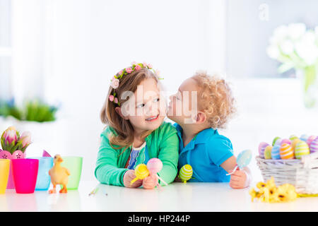 Pittura per bambini uova colorate. I bambini di vernice e decorare uovo di Pasqua. Il Toddler kid e preschooler bambino giocare in ambienti interni in primavera. Casa decorata con SPR Foto Stock