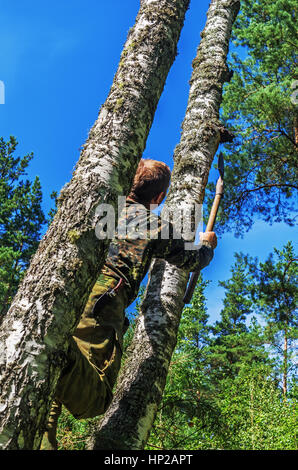 L'uomo rimuove un fungo chaga di betulla. Foto Stock