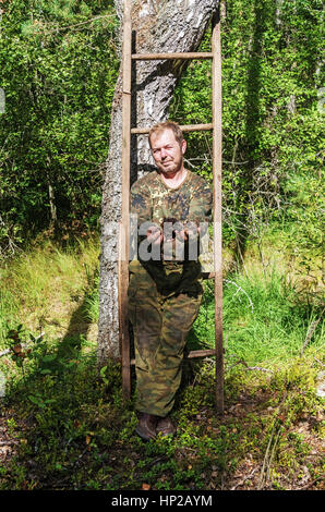 L'uomo rimuove un fungo chaga di betulla. Foto Stock