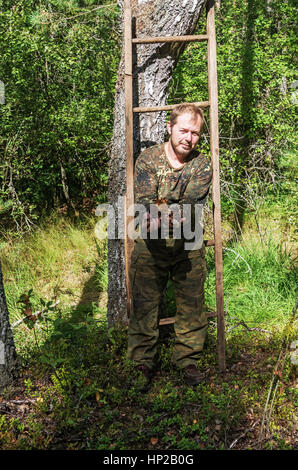 L'uomo rimuove un fungo chaga di betulla. Foto Stock