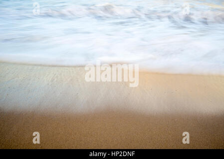 In prossimità della spiaggia di sabbia e onde. lunga esposizione dell'immagine. Foto Stock