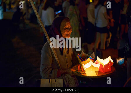 Vecchia donna vendita di candele per la luna piena festival nella città vecchia di Hoi An, Vietnam Foto Stock