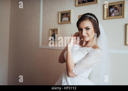 Giorno di nozze. Bella Sposa cercando su orecchini Foto Stock