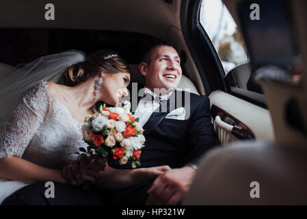 Coppia giovane in un auto nel giorno del matrimonio. Foto Stock