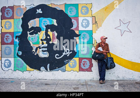 Fornitore di arachidi 'manisero' e propaganda politica,volto di Che Guevara, dipinta su un muro di strada, La Habana, Cuba Foto Stock