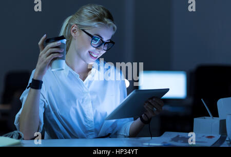 Felice programmatore femmina utilizzando tablet in ufficio Foto Stock