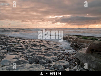 Onde in rotolamento come la marea sale all'alba sulla costa nordorientale del Regno Unito Foto Stock