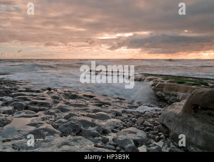 Onde in rotolamento come la marea sale all'alba sulla costa nordorientale del Regno Unito Foto Stock