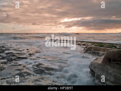 Onde in rotolamento come la marea sale all'alba sulla costa nordorientale del Regno Unito Foto Stock