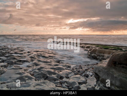 Onde in rotolamento come la marea sale all'alba sulla costa nordorientale del Regno Unito Foto Stock