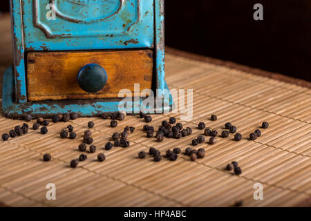 Vecchio macinino di pepe e del pepe sul tappeto in legno Foto Stock