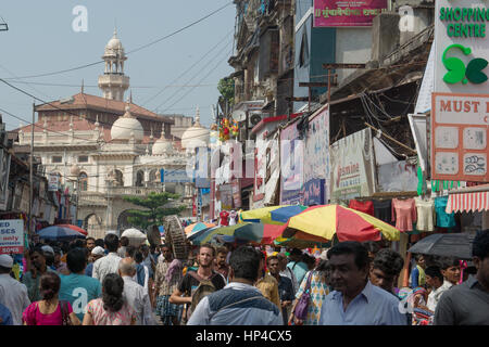 Mumbai, India - 19 Ottobre 2015 - zona musulmana Bhendi Bazaar con moschea in background con persone che si muovono lentamente nel molto strade affollate e traff Foto Stock