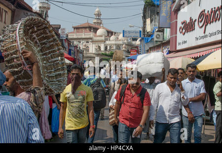 Mumbai, India - 19 Ottobre 2015 - zona musulmana Bhendi Bazaar con moschea in background con persone che si muovono lentamente nel molto strade affollate e traff Foto Stock