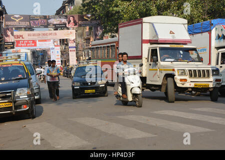 Mumbai, India - 10 Ottobre 2015 - Uomo pacchetto trasporta sulla sua testa muovendo lentamente in molto affollate strade e traffico in Kochi con tuk tuk e imposte Foto Stock