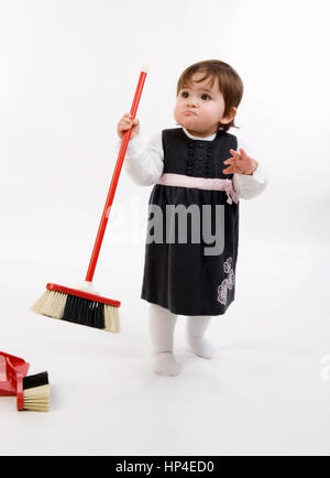 Modello rilasciato , Kleines Maedchen, 1 Jahr, mit Besen - bambina con la scopa polverosi Foto Stock