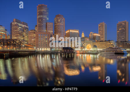 Lo skyline si riflette ancora le acque del porto dell'ultima ora prima dell'alba di un nuovo giorno inizia a Boston, Massachusetts. Foto Stock