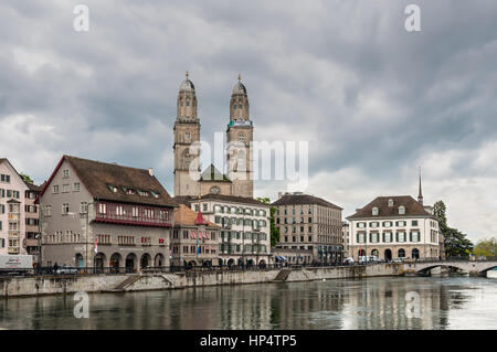 Zurich, Svizzera - 24 Maggio 2016: vista della chiesa Grossmunster (grande Minster), varie case e Limmat a Zurigo nel cielo coperto weath piovosa Foto Stock