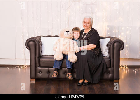Vecchia nonna con suo nipote seduto su un divano. Foto Stock