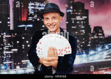 Il mago che mostra trucco con carte da gioco. Magic Circus Foto Stock