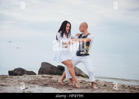 Bella coppia danzante sulla spiaggia di sfondo Foto Stock