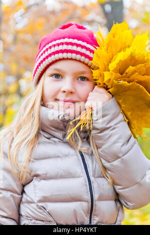 Foto della ragazza con bouquet da fogli in autunno Foto Stock