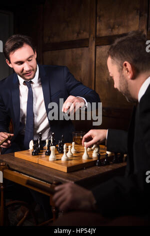 Ricchi uomini d'affari giocando a scacchi Foto Stock