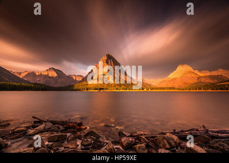 Sunrise nel Glacier National Park. Esposizione a lungo con il monte grinnell come punto focale di sunrise. nuvole di fumo e da incendi boschivi creato il dramat Foto Stock