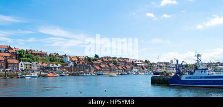 Un ampia vista delle barche ed edifici intorno al porto di Whitby, North Yorkshire, Regno Unito Foto Stock