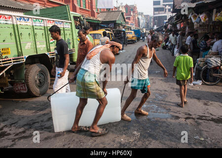 Enormi blocchi di ghiaccio,,essendo,trasportati,oltre,sudicia,pavimento,a,Hogg mercato,Kolkata,Calcutta,West Bengal,West Bengala,,l'India,Indian,Asia,asiatica, Foto Stock