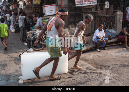 Enormi blocchi di ghiaccio,,essendo,trasportati,oltre,sudicia,pavimento,a,Hogg mercato,Kolkata,Calcutta,West Bengal,West Bengala,,l'India,Indian,Asia,asiatica, Foto Stock