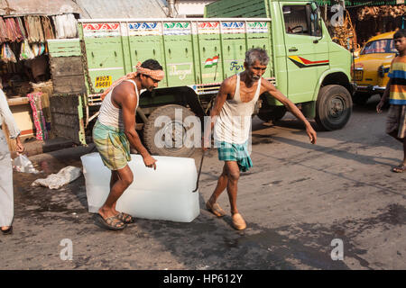 Enormi blocchi di ghiaccio,,essendo,trasportati,oltre,sudicia,pavimento,a,Hogg mercato,Kolkata,Calcutta,West Bengal,West Bengala,,l'India,Indian,Asia,asiatica, Foto Stock