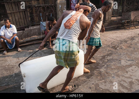 Enormi blocchi di ghiaccio,,essendo,trasportati,oltre,sudicia,pavimento,a,Hogg mercato,Kolkata,Calcutta,West Bengal,West Bengala,,l'India,Indian,Asia,asiatica, Foto Stock