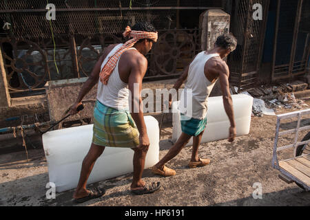 Enormi blocchi di ghiaccio,,essendo,trasportati,oltre,sudicia,pavimento,a,Hogg mercato,Kolkata,Calcutta,West Bengal,West Bengala,,l'India,Indian,Asia,asiatica, Foto Stock