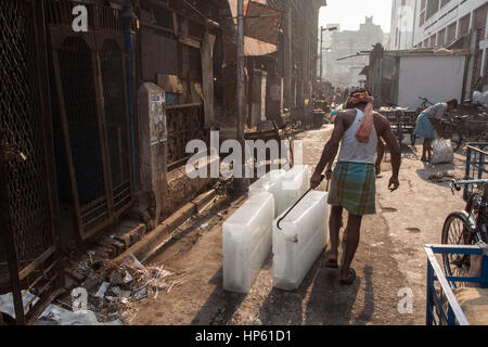 Enormi blocchi di ghiaccio,,essendo,trasportati,oltre,sudicia,pavimento,a,Hogg mercato,Kolkata,Calcutta,West Bengal,West Bengala,,l'India,Indian,Asia,asiatica, Foto Stock