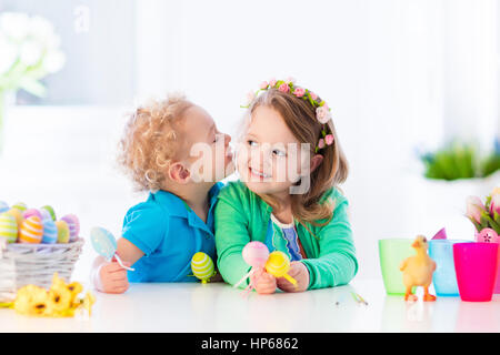 Pittura per bambini uova colorate. I bambini di vernice e decorare uovo di Pasqua. Il Toddler kid e preschooler bambino giocare in ambienti interni in primavera. Casa decorata con SPR Foto Stock