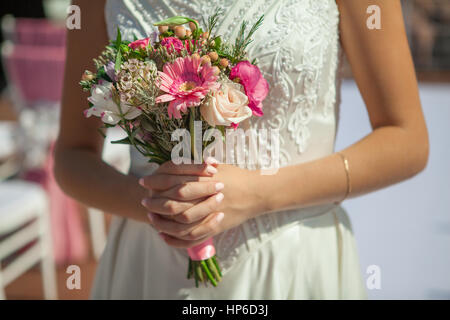 La donna può contenere piccole bouquet rosa in mani Foto Stock