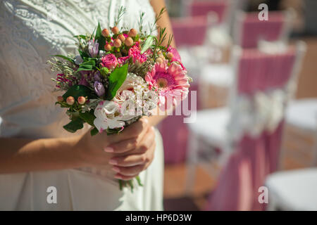 La donna può contenere piccole bouquet rosa in mani Foto Stock