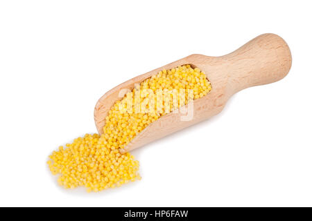 Cucchiaio di legno con miglio dorato isolati su sfondo bianco. Miglio non cotte nel convogliatore di legno isolato su bianco Foto Stock