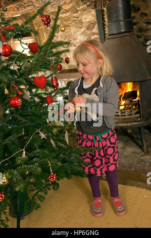 Milly Tatham decorare un tradizionale albero di Natale in un cottage in Devon Foto Stock